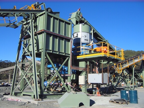 A large machine with a conveyor belt, also known as a belt conveyor, in front of it.
