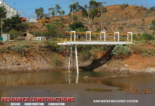 An auto draft bridge over a river with a dam in the background.