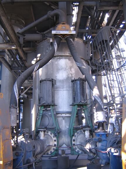 A large metal structure with pipes, hoses, and conveyors.