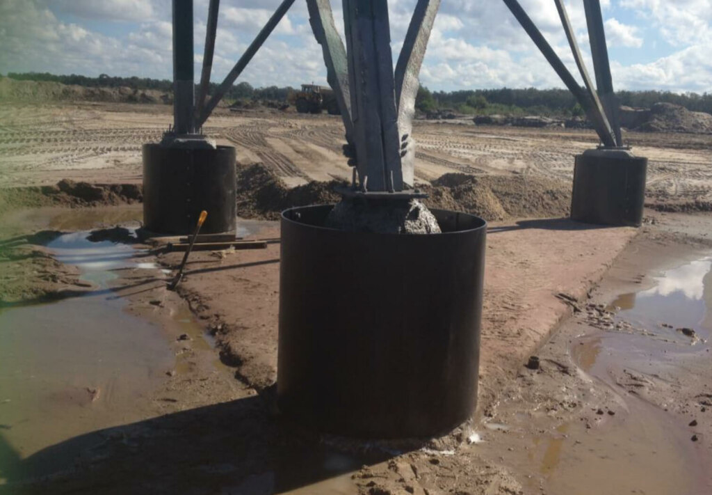 A construction site undergoing tower repair amidst a cyclone, resulting in a lot of dirt and mud.