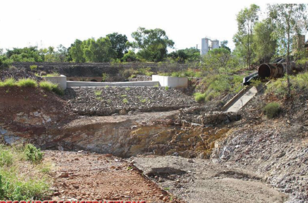 The construction of a dam on a dirt road, utilizing belt conveyors for efficient transportation.