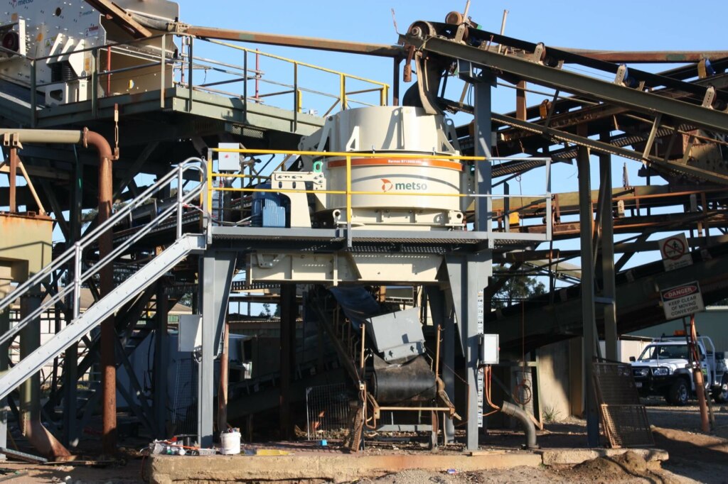 A large industrial plant with a refurbished conveyor belt for gravel crushing and screening.