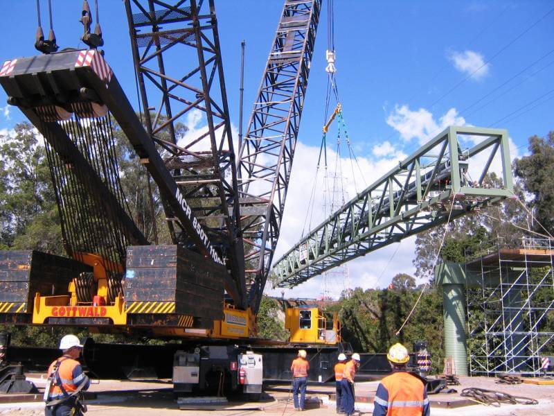 A large crane is lifting a large piece of equipment.