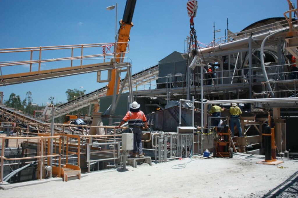 A group of workers are utilizing belt conveyors on a construction site.