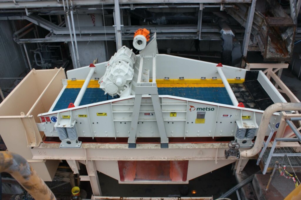 A large machine is sitting on top of a conveyor belt.